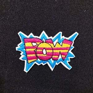 Colorful 'POW' Patch on Black Fabric Iron On